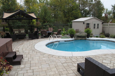 Design ideas for a mid-sized full sun backyard concrete paver landscaping in Ottawa for summer.
