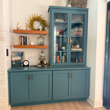 Deep Teal Built-In Cabinetry with Glass Display and Floating Shelves