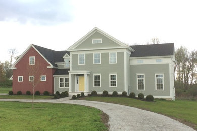 Example of a large transitional green two-story wood exterior home design in New York with a shingle roof