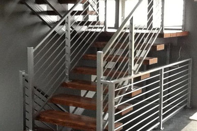 Diseño de escalera suspendida actual de tamaño medio con escalones de madera y contrahuellas de metal