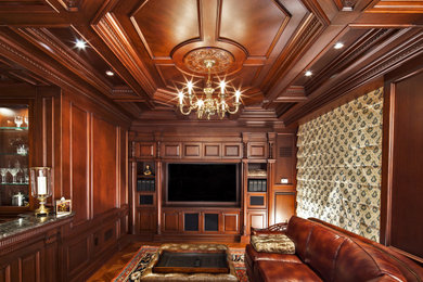 Diseño de salón con barra de bar cerrado clásico de tamaño medio con paredes marrones, suelo de madera clara, pared multimedia, suelo marrón, casetón y madera