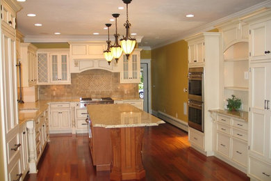 Eat-in kitchen - traditional u-shaped eat-in kitchen idea in Boston with an undermount sink, beaded inset cabinets, white cabinets, beige backsplash and stainless steel appliances