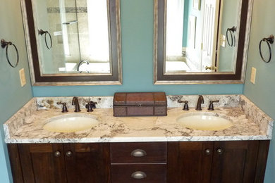 Example of a small transitional master beige tile and porcelain tile porcelain tile bathroom design in Charlotte with an undermount sink, flat-panel cabinets, dark wood cabinets, granite countertops, a two-piece toilet and blue walls