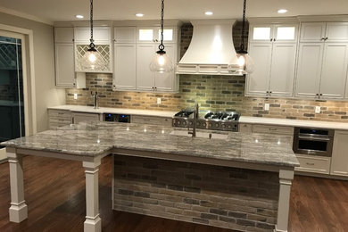 Example of a mid-sized mountain style single-wall dark wood floor and brown floor kitchen design in Atlanta with an undermount sink, beaded inset cabinets, white cabinets, granite countertops, multicolored backsplash, brick backsplash, white appliances, an island and gray countertops