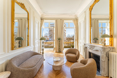 Cette photo montre un salon tendance avec un mur blanc, un sol en bois brun, une cheminée standard, un sol marron et du lambris.