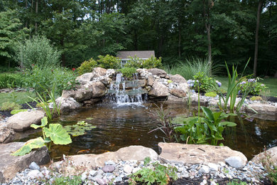 Large elegant backyard concrete paver patio fountain photo in Philadelphia