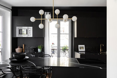 パリにある高級な広いおしゃれなキッチン (インセット扉のキャビネット、黒いキャビネット、珪岩カウンター、黒いキッチンパネル、テラコッタタイルのキッチンパネル、淡色無垢フローリング、黒いキッチンカウンター) の写真
