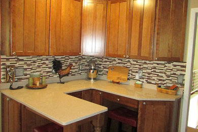 Mid-sized arts and crafts l-shaped porcelain tile eat-in kitchen photo in Other with an undermount sink, shaker cabinets, quartz countertops, red backsplash, mosaic tile backsplash, stainless steel appliances and a peninsula