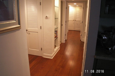 Large traditional hallway in Miami with white walls and dark hardwood floors.