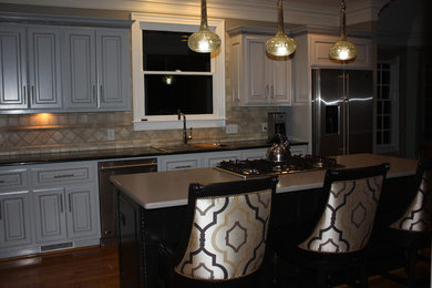 Large transitional u-shaped light wood floor eat-in kitchen photo in Other with a double-bowl sink, raised-panel cabinets, gray cabinets, quartz countertops, beige backsplash, ceramic backsplash, stainless steel appliances and an island