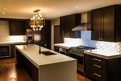 Inspiration for a large modern l-shaped dark wood floor and brown floor kitchen remodel in Atlanta with a single-bowl sink, shaker cabinets, dark wood cabinets, quartz countertops, white backsplash, marble backsplash, stainless steel appliances and white countertops