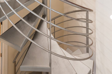 Imagen de escalera de caracol actual de tamaño medio con escalones de metal y contrahuellas de metal