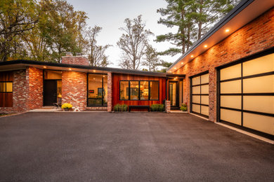 Example of a mid-sized one-story brick house exterior design in DC Metro with a metal roof and a black roof