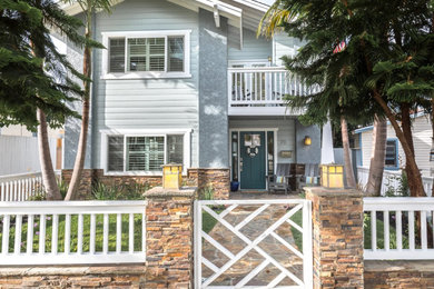 Beach style blue two-story stucco exterior home photo in Other