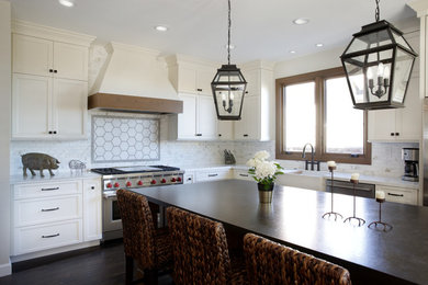 Mid-sized elegant l-shaped dark wood floor kitchen photo in San Francisco with a farmhouse sink, recessed-panel cabinets, white cabinets, solid surface countertops, white backsplash, marble backsplash, stainless steel appliances, an island and multicolored countertops