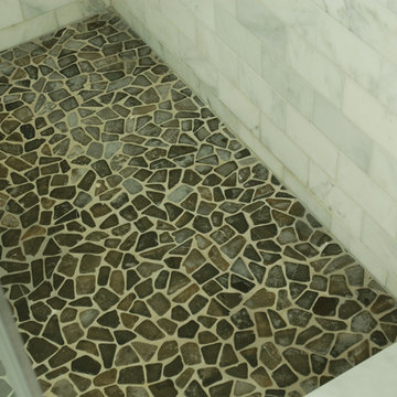 Shower base with pebbles.