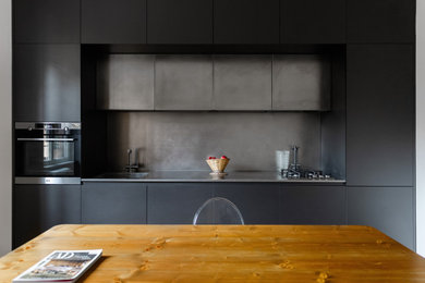Foto di una cucina design con ante nere, top in acciaio inossidabile e top grigio