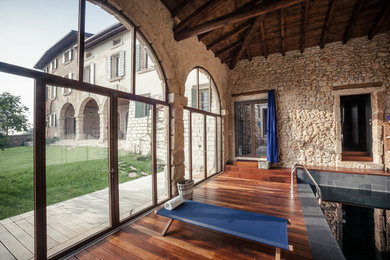 Foto de piscina alargada actual grande interior y rectangular con adoquines de piedra natural