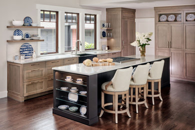 Example of a mid-sized transitional dark wood floor, brown floor and vaulted ceiling eat-in kitchen design in Boston with a farmhouse sink, shaker cabinets, medium tone wood cabinets, quartzite countertops, white backsplash, stone slab backsplash, paneled appliances, an island and yellow countertops