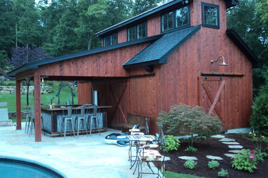 Large cottage backyard stone patio kitchen photo in New York with a roof extension