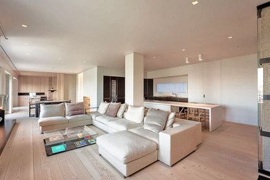 Trendy medium tone wood floor living room photo in New York with white walls