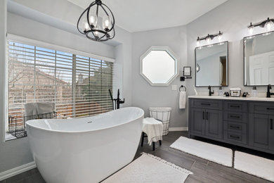 Trendy master multicolored tile and ceramic tile porcelain tile, brown floor and double-sink bathroom photo in Sacramento with gray cabinets, gray walls, an undermount sink, marble countertops, a hinged shower door, white countertops and a freestanding vanity