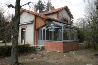 Cette image montre une façade de maison grise minimaliste en verre de taille moyenne et de plain-pied.