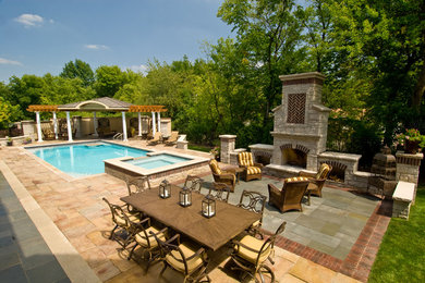 Design ideas for a large traditional backyard patio in Chicago with natural stone pavers, a fire feature and no cover.