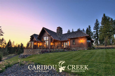 Example of a large mountain style brown two-story wood house exterior design in Other with a clipped gable roof and a shingle roof