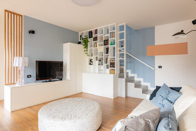 Foto de biblioteca en casa abierta moderna de tamaño medio sin chimenea con paredes azules, suelo vinílico, televisor independiente y suelo marrón