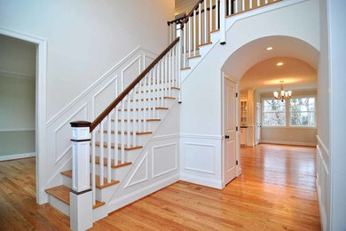 Photo of a large contemporary wood l-shaped staircase in New York with painted wood risers.