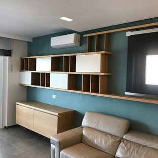 Foto på ett funkis vardagsrum, med blå väggar, tegelgolv, en inbyggd mediavägg och grått golv