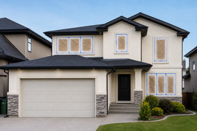 Example of a large trendy beige two-story stucco house exterior design in Edmonton