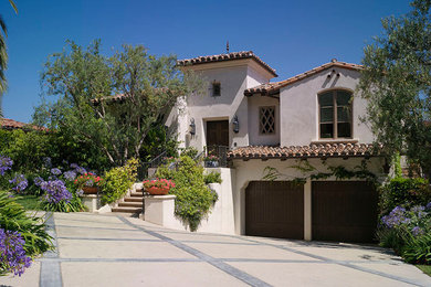 Example of a mid-sized tuscan white two-story stucco gable roof design in Los Angeles