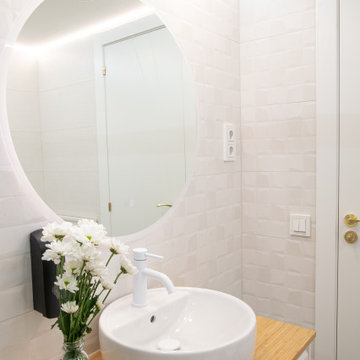 Vista desde la ducha: mueble de baño con iluminación perimetral y detalles dorad