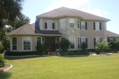 Inspiration for a large timeless beige two-story stucco exterior home remodel in Orlando