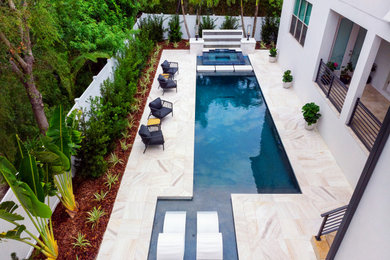 Photo of a mid-sized contemporary custom-shaped pool in Tampa with tile.