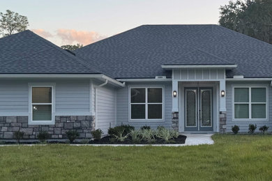 Example of a classic gray one-story concrete fiberboard and board and batten house exterior design in Jacksonville with a shingle roof and a gray roof