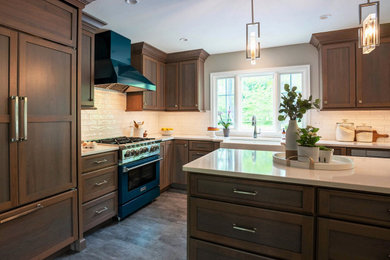 Eat-in kitchen - mid-sized contemporary l-shaped vinyl floor and gray floor eat-in kitchen idea in Philadelphia with a farmhouse sink, shaker cabinets, dark wood cabinets, quartz countertops, white backsplash, subway tile backsplash, paneled appliances, an island and gray countertops