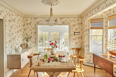 Example of a transitional light wood floor, beige floor and wallpaper dining room design in New York with multicolored walls