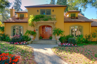 Example of a large tuscan yellow two-story stucco gable roof design in San Francisco