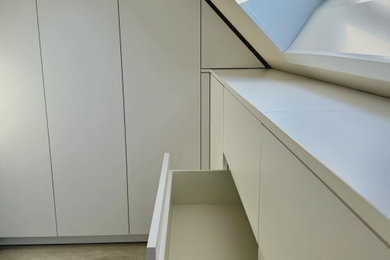 Foto de vestidor minimalista de tamaño medio con armarios con paneles lisos, puertas de armario blancas, suelo de madera en tonos medios, suelo marrón y papel pintado