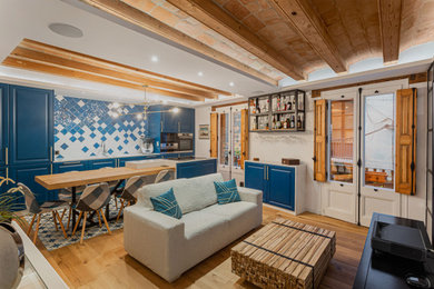 Imagen de salón abierto, abovedado y blanco y madera mediterráneo de tamaño medio sin chimenea con paredes blancas y suelo de madera en tonos medios