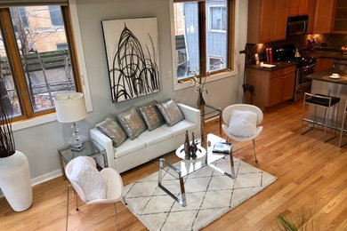 Modelo de salón abierto minimalista pequeño con paredes grises, suelo de madera en tonos medios y suelo marrón