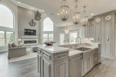 Large elegant u-shaped dark wood floor and gray floor open concept kitchen photo in DC Metro with a farmhouse sink, raised-panel cabinets, distressed cabinets, granite countertops, beige backsplash, ceramic backsplash, stainless steel appliances, an island and gray countertops