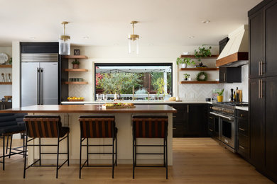 Example of a large transitional light wood floor and multicolored floor kitchen design in Other with an undermount sink, yellow backsplash, subway tile backsplash, stainless steel appliances and an island