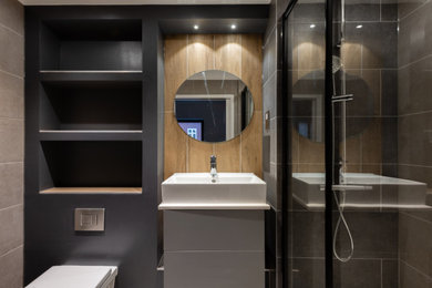 Medium sized contemporary grey and brown shower room bathroom in London with a walk-in shower, a one-piece toilet, grey tiles, grey walls, a hinged door, white worktops, feature lighting and a single sink.