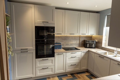 Design ideas for a medium sized classic grey and black l-shaped enclosed kitchen in Other with a built-in sink, shaker cabinets, grey cabinets, laminate countertops, multi-coloured splashback, porcelain flooring, no island, brown floors, brown worktops and a feature wall.