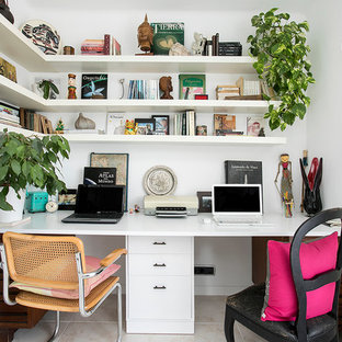Inredning av ett exotiskt mellanstort hemmabibliotek, med vita väggar och ett inbyggt skrivbord