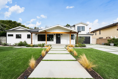 Huge minimalist white two-story concrete fiberboard and board and batten exterior home photo in Orange County with a mixed material roof and a gray roof